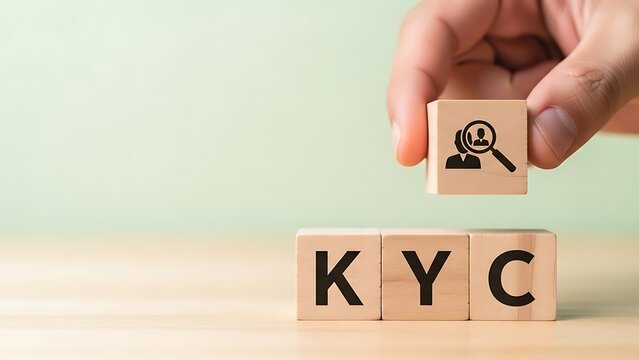 Know your customer concept with a hand holding a wooden block with a person s icon above kyc blocks