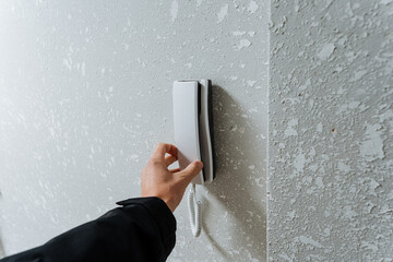 door security scene, secure entry environment with wired speakerphone and intercom handset, hand...