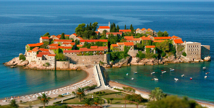 Sveti Stefan island is photographed from a high mountain in Montenegro against the backdrop of the bright blue and blue sea.