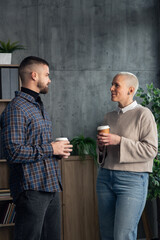 Colleagues having a conversation during coffee break in office