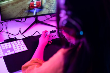 Hands of a gamer using a controller in a low-light environment, emphasizing focus and immersion.