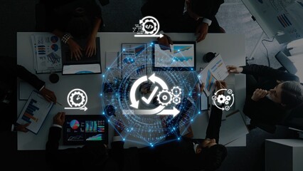 A diverse business team collaborates in an office setting, using technology to enhance workflow efficiency through strategic discussions and presentations. Raster