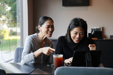 An Asian freelance woman comes to a coffee shop to brainstorm and to chat with friends.