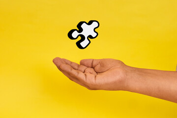 A problem solving concept illustrated by a hand holding a puzzle piece, symbolizing solutions, clarity and strategic thinking.
