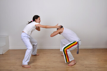 Naklejka premium professor e aluna treino capoeira em escola 