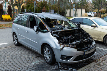 Burnt passenger car standing on the city street. Vehicle with interior largely burnt out.