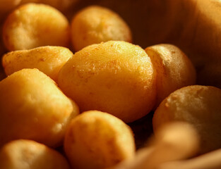Golden potato croquettes cooking with a warm light, creating a comforting rustic food texture