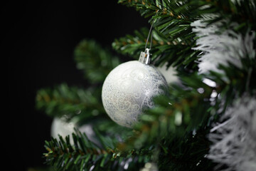 Silver Christmas bauble decorating a festive green tree