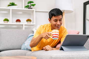 Young man relaxing working from home using tablet
