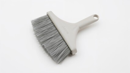 A brush with gray bristles and a white handle on a plain background.
