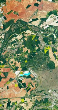 Flying above fertile land and soil, agricultural district. Camera is zooming out, rotating counterclockwise. Vertical video. Animation based on image by NASA