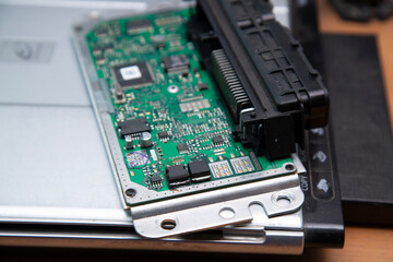 Electrician works with electric block in car. Close-up of automobile inside under raised hood. Service man hands working with cables of auto