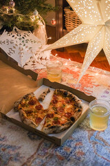 Take away pizza and a couple of drinks on the floor, Christmas decorations