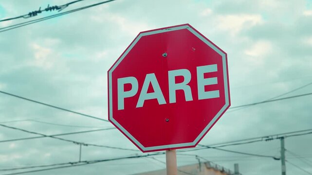 Octagonal red road sign with the word PARE