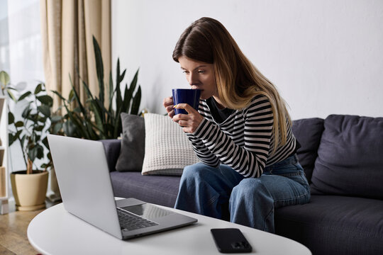 A young woman sipping coffee in her apartment. - Powered by Adobe