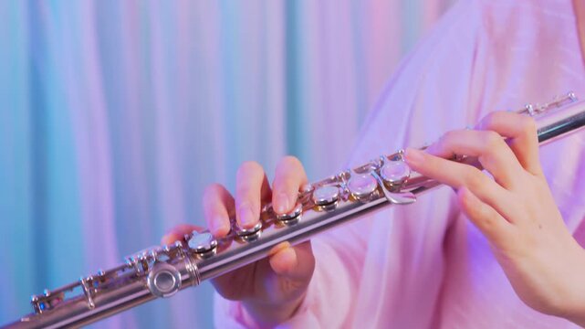 フルートを吹いている人の手元のクローズアップ：ピンク