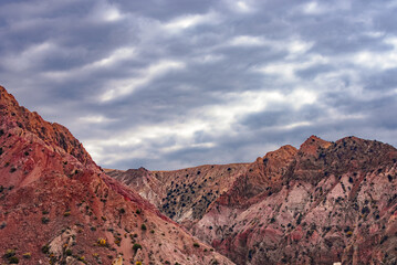 A mountain range with a cloudy sky in the background