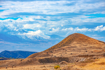 A mountain range is visible in the distance, with a large hill in the foreground