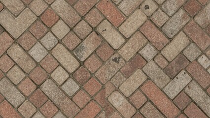 Obraz premium Pattern of brick paving stones arranged in a herringbone design.