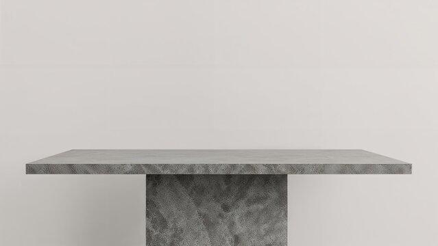 A minimalist gray table with a single pedestal base against a plain white wall background.