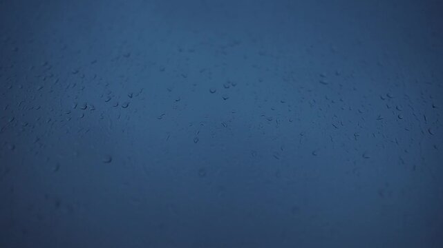 Detailed shot showing rain droplets adorning bluetinted glass