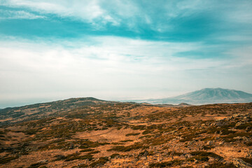 A vast, barren landscape with a mountain in the distance