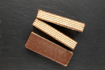 Sweet chocolate wafers cut into pieces, top view, macro.