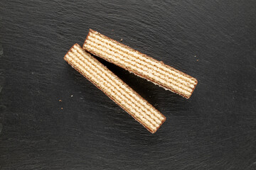 Sweet chocolate wafers cut into pieces, top view, macro.