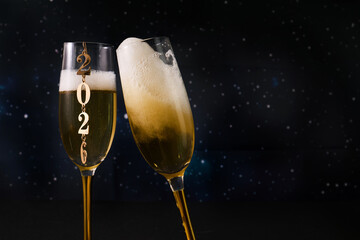 New Year Celebration. Two champagne glasses against a starry backdrop celebrating 2026.