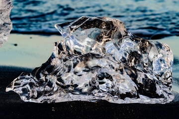 Intricate glass-like ice formation on the black shores of Diamond Beach, Iceland