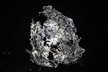 Intricate backlit ice formation glowing against a pitch black background