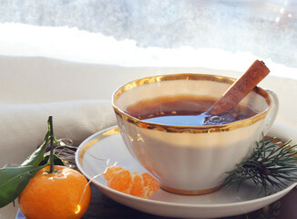 A mug of hot black tea on the windowsill. Christmas atmosphere.