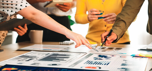 A dynamic team collaborates in a modern office setting, analyzing financial data and business reports through charts and graphs for informed decision-making and strategy. SACTR