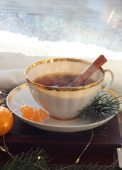 A mug of hot black tea on the windowsill. Christmas atmosphere.