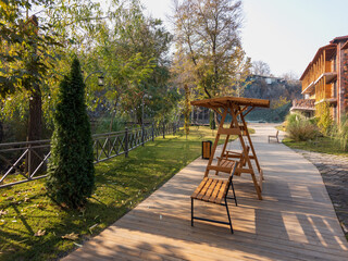 A wooden bench is on a path in a park
