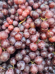 Fresh ripe red Grapes in the market. Food and fruit background. Top view, close-up. Fruits for sale in the supermarket.