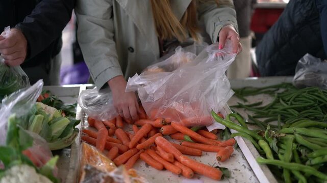 Woman selecting fresh carrots at farmers market