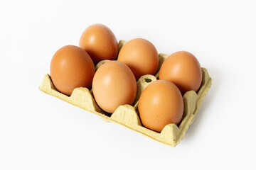 Six organic brown eggs in a carton isolated on white background