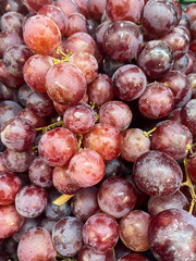 Fresh ripe red Grapes in the market. Food and fruit background. Top view, close-up. Fruits for sale in the supermarket.