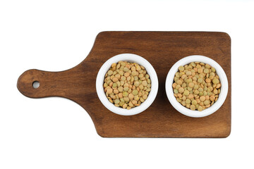Green lentils in wooden bowl on isolated white background. Top view, copy space. Flat lay.