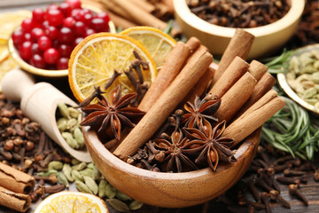 Different spices, dry orange slices and cranberries for mulled wine on table, closeup
