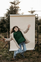 M&auml;dchen, 11,  springt vor beigem Studiohintergrund in der Natur