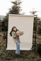 M&auml;dchen, 11, mit Weihnachtsgeschenk vor beigem Studiohintergrund in der Natur