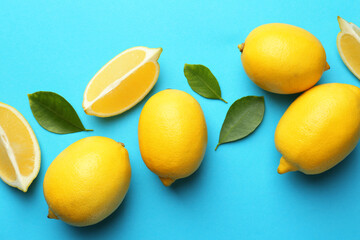 Fresh ripe lemons and leaves on light blue background, flat lay
