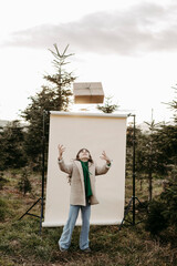 M&auml;dchen, 11, mit Weihnachtsgeschenk vor beigem Studiohintergrund in der Natur