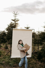 M&auml;dchen, 11, mit Weihnachtsgeschenk vor beigem Studiohintergrund in der Natur