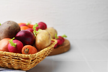 Different raw vegetables on white tiled table, closeup. Space for text