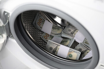 Many dollar banknotes in washing machine, closeup