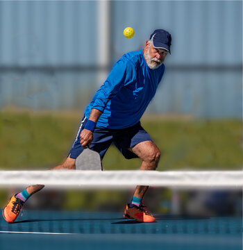 Male pickleball player keeps his eyes on the ball after hitting a slice