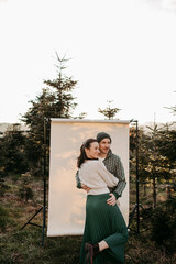 Paar vor einem beigen Studiohintergrund in freier Natur